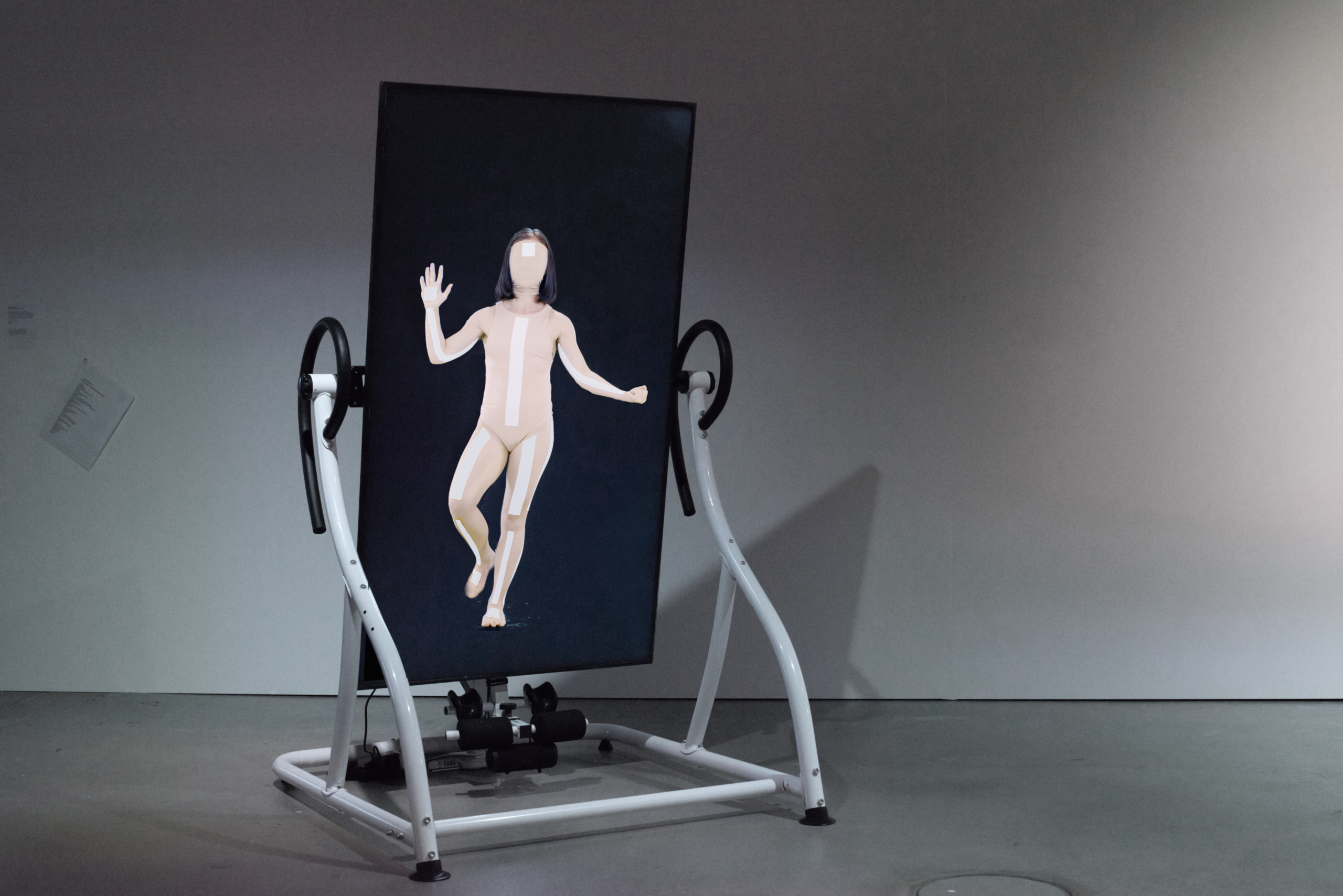 Coralie Vogelaar. Infinite Posture Dataset, video installation with a motorised Relax Zone Pro Inversion Table, 2020. Dancer: Courtney May Robertson, Choreography i.c.w Marjolein Vogels Installation shot at HeK (House of electronic Arts) Basel